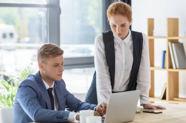 Başarılı takım modern ofis içinde laptop tarafından proje tartışıyor  