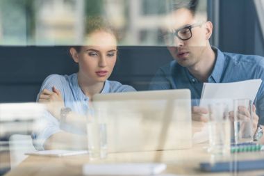 Düşünceli işadamı ve modern ofis projesinde tartışırken işkadını cam görünümü  