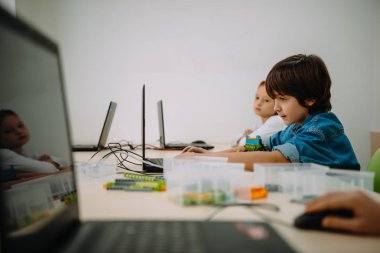 concetrated kids working with computers on stem education class clipart