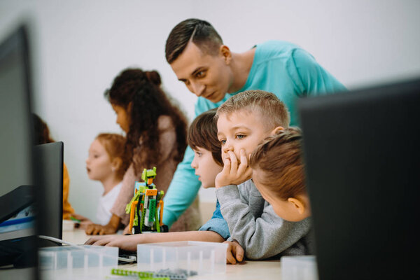 children working with teacher on their robot education project