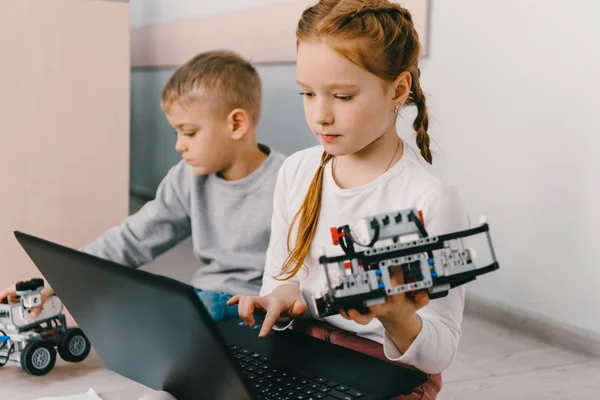 Giovanissima Studentessa Programmazione Robot Mentre Seduta Pavimento Con Capretto — Foto Stock