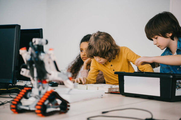 focused little kids constructing diy robots, stem education concept