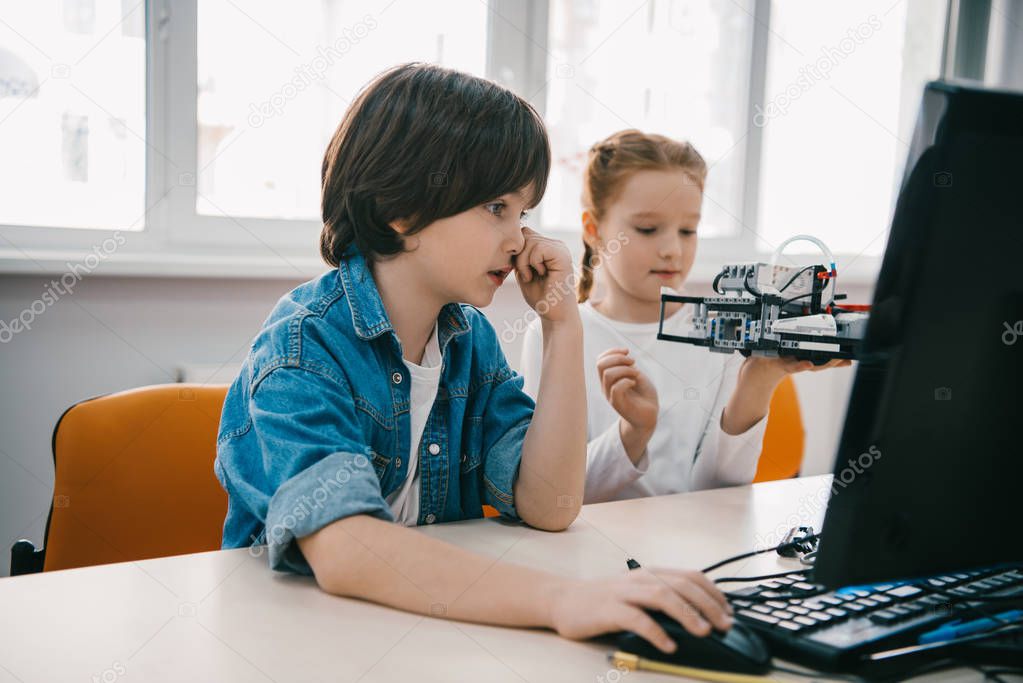 children programming robots together, stem education concept