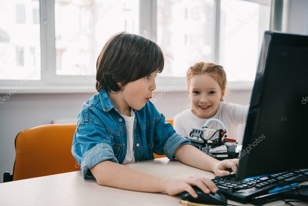 excited children programming robots together, stem education concept