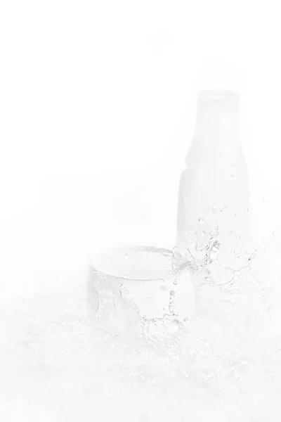 Wassertropfen fallen auf Flasche und Schachtel — Stockfoto