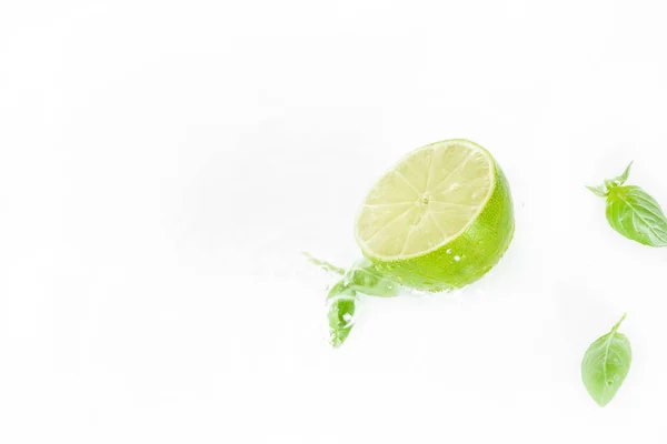 La moitié du citron vert avec des feuilles vertes — Photo de stock