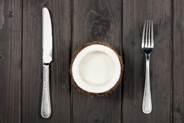 Mitad de coco con tenedor de metal y cuchillo - foto de stock