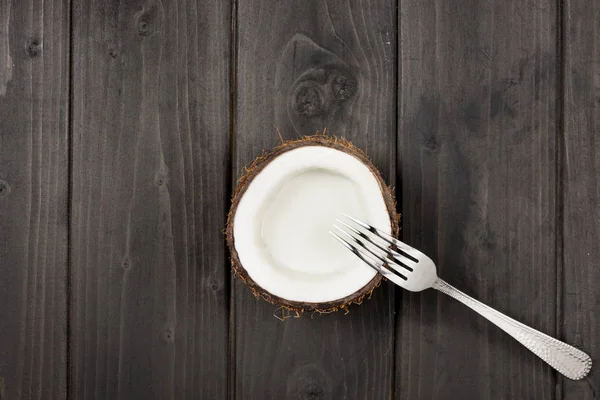 Mitad de coco y tenedor de metal - foto de stock