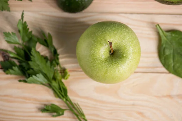 Manzana con perejil sobre mesa de madera - foto de stock