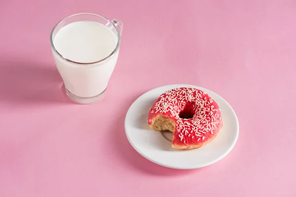 Стакан молока с пончиком на тарелке — стоковое фото