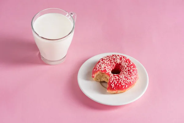 Vaso de leche con rosquilla en el plato - foto de stock