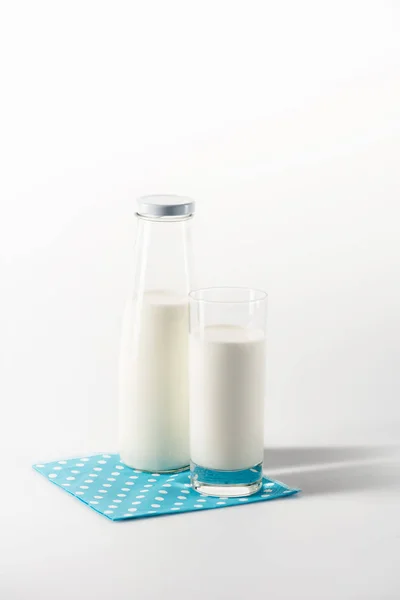 Milk in glass and bottle on napkin — Stock Photo