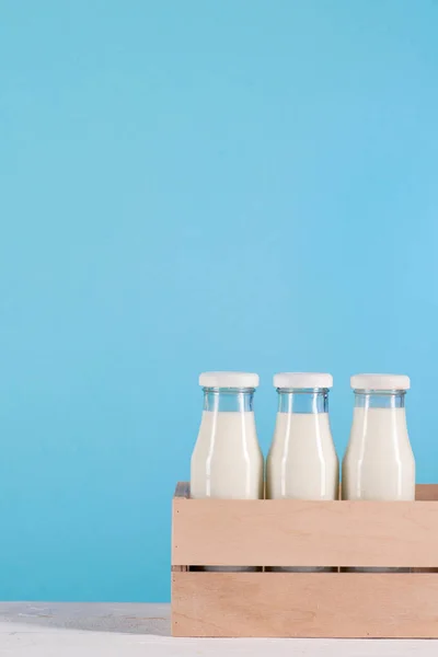 Glasflaschen mit Milch in Holzkiste — Stockfoto