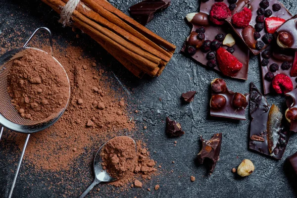 Pieces of chocolate with nuts and berries with cinnamon — Stock Photo