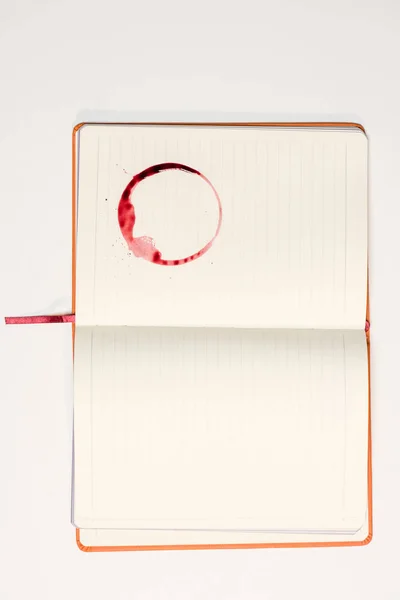 Caderno em branco com mancha de vinho tinto — Fotografia de Stock