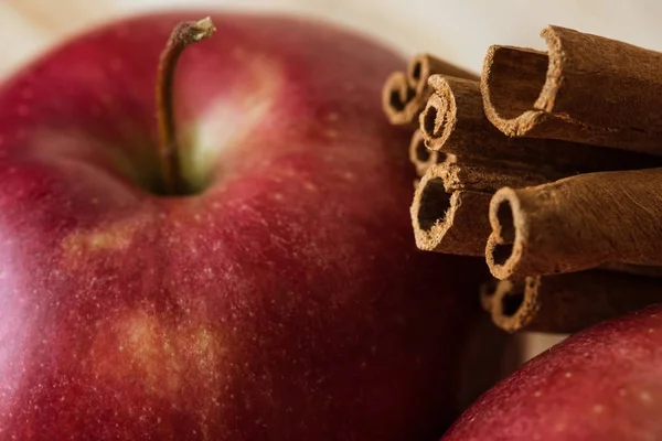 Red apple and cinnamon sticks — Stock Photo