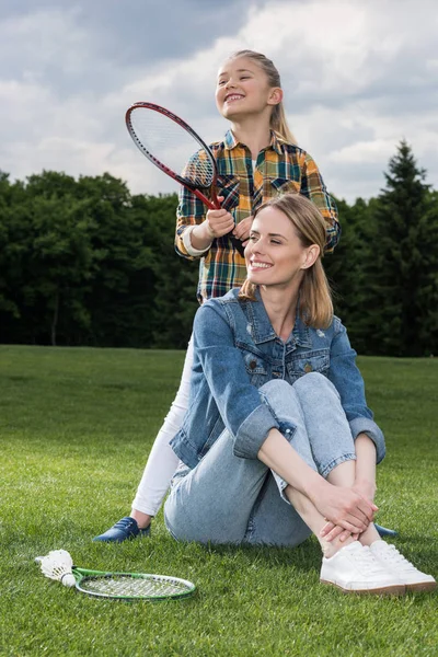 Mother and daughter resting on green lawn — Stock Photo