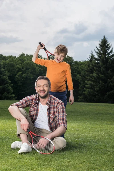 Père et fils reposant sur la pelouse verte — Photo de stock
