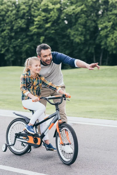 Padre enseñanza chica equitación bicicleta - foto de stock