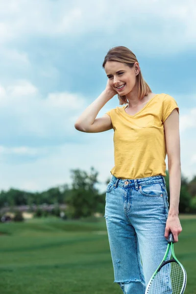 Woman posing with badminton racket at park — Stock Photo