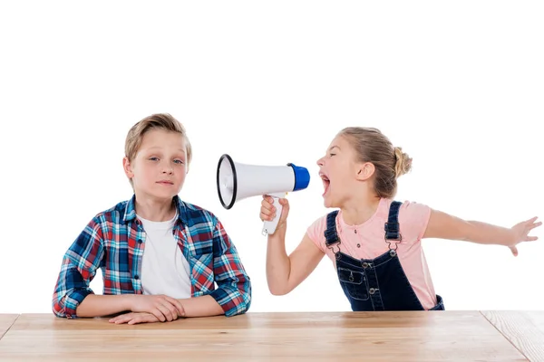 Ragazza con megafono urlando su suo fratello — Foto stock