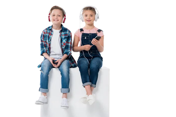 Niños escuchando música en auriculares - foto de stock