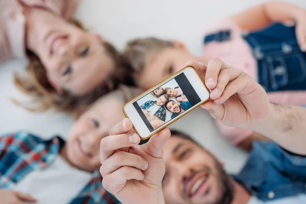 Happy family taking selfie on smartphone — Stock Photo