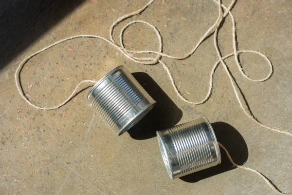 Aluminium tin cans connected with rope — Stock Photo