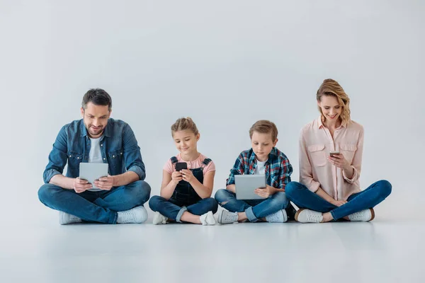 Счастливое семейство с помощью цифровых устройств — стоковое фото