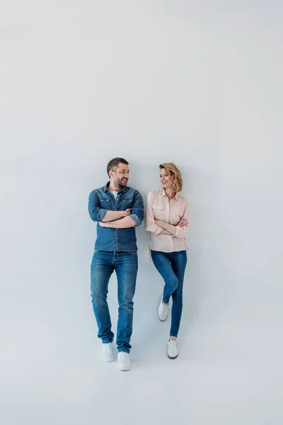 Pareja de pie junto con los brazos cruzados - foto de stock