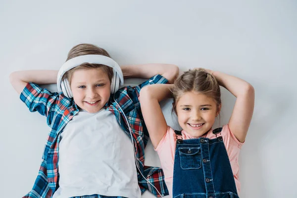 Niños mirando a la cámara con las manos en la cabeza - foto de stock