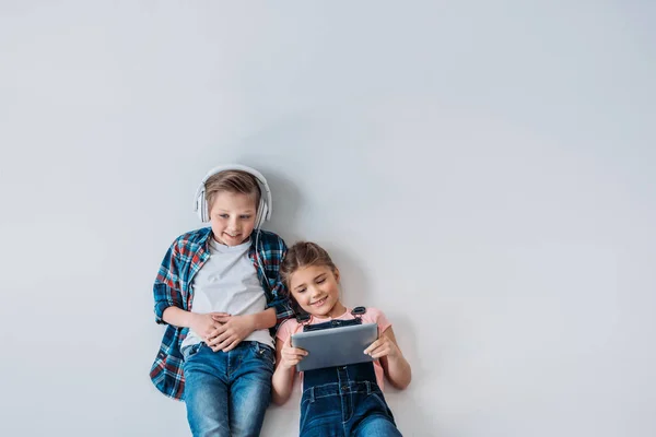 Enfants occasionnels utilisant des appareils numériques — Photo de stock