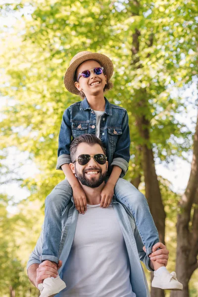 Father carrying daughter on shoulders — Stock Photo