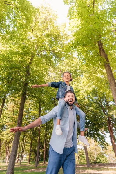 Father carrying daughter on shoulders — Stock Photo