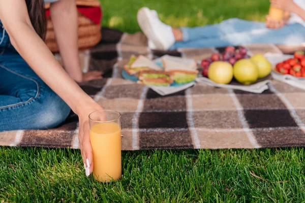 Person trinkt Saft beim Picknick — Stockfoto