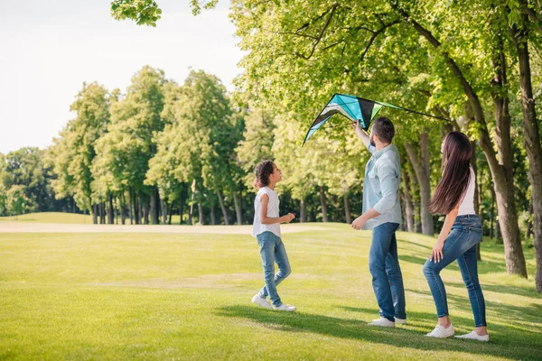 Семья играет с воздушным змеем — стоковое фото