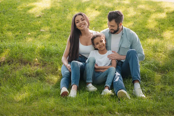 Family resting on green lawn — Stock Photo