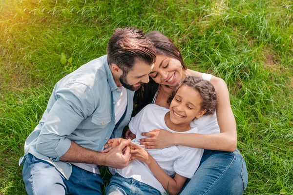 Famiglia che riposa sul prato verde — Foto stock