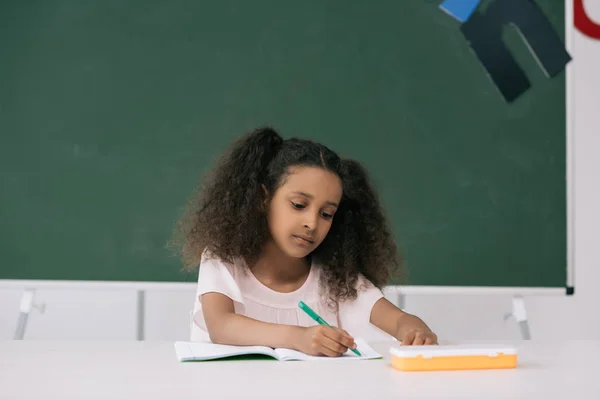 African american schoolgirl in classroom — Stock Photo