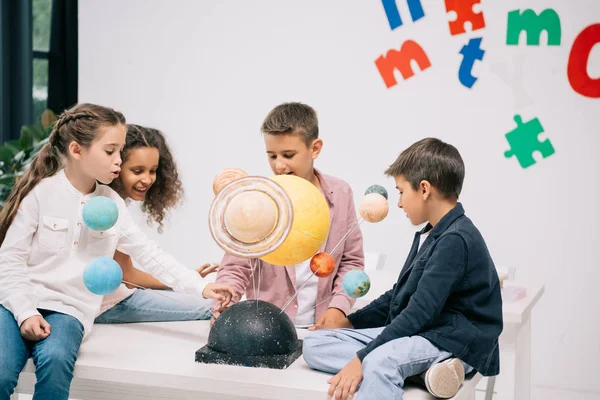 Schoolchildren with solar system — Stock Photo