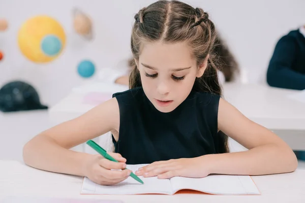 Schoolgirl studying in classroom — Stock Photo