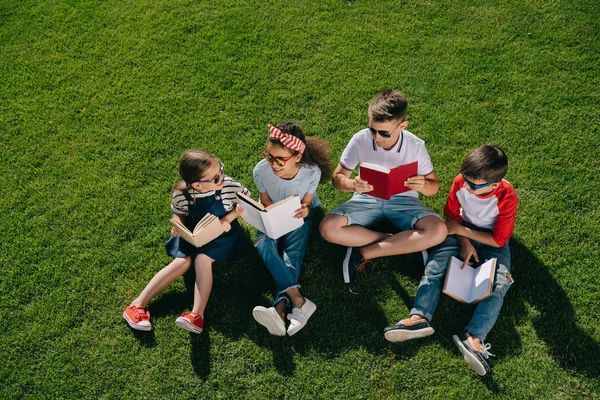 Niños leyendo libros en el parque - foto de stock