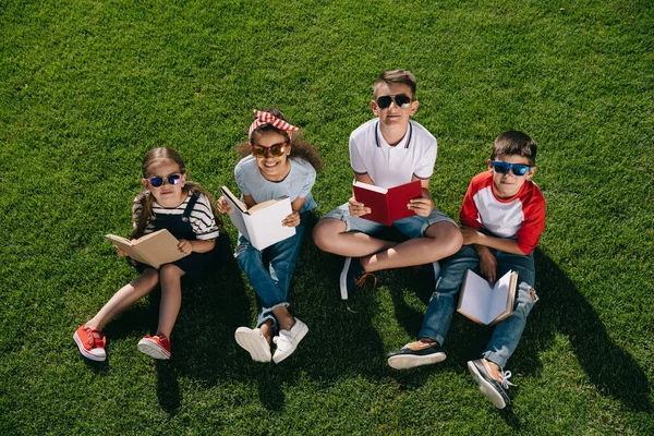 Enfants lisant des livres dans le parc — Photo de stock