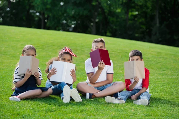 Bambini che leggono libri nel parco — Foto stock