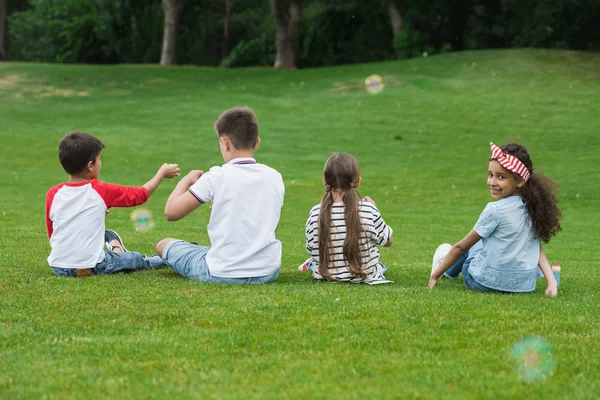 Niños multiétnicos jugando en el parque - foto de stock