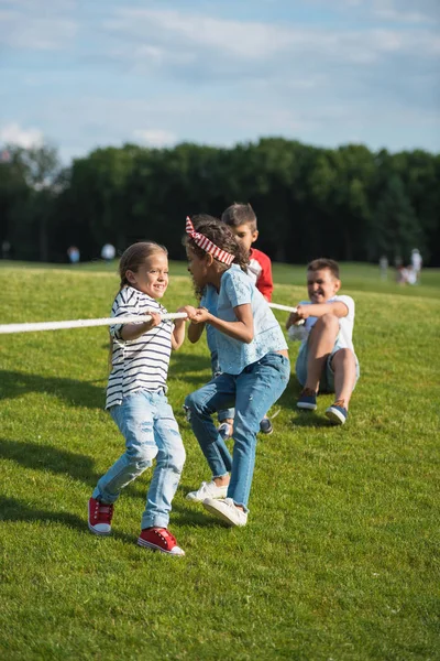 Niños jugando tirón de la guerra - foto de stock