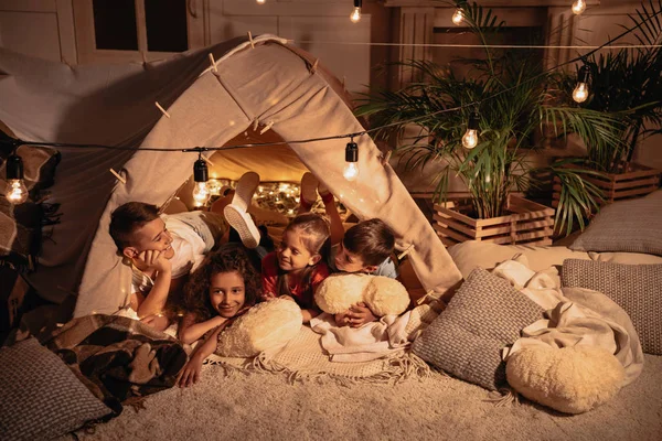 Niños multiétnicos descansando en la tienda - foto de stock