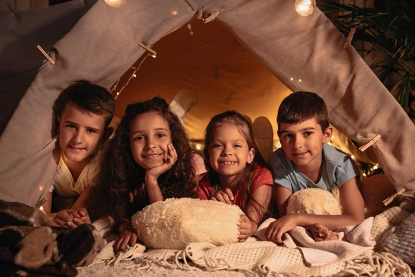 Niños multiétnicos descansando en la tienda - foto de stock