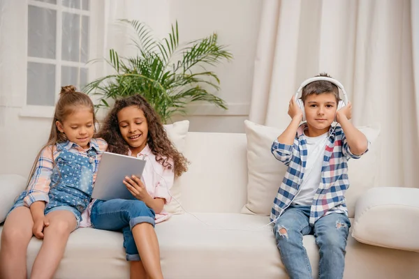 Enfants avec des appareils numériques à la maison — Photo de stock