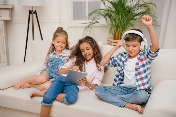 Crianças com dispositivos digitais em casa — Fotografia de Stock